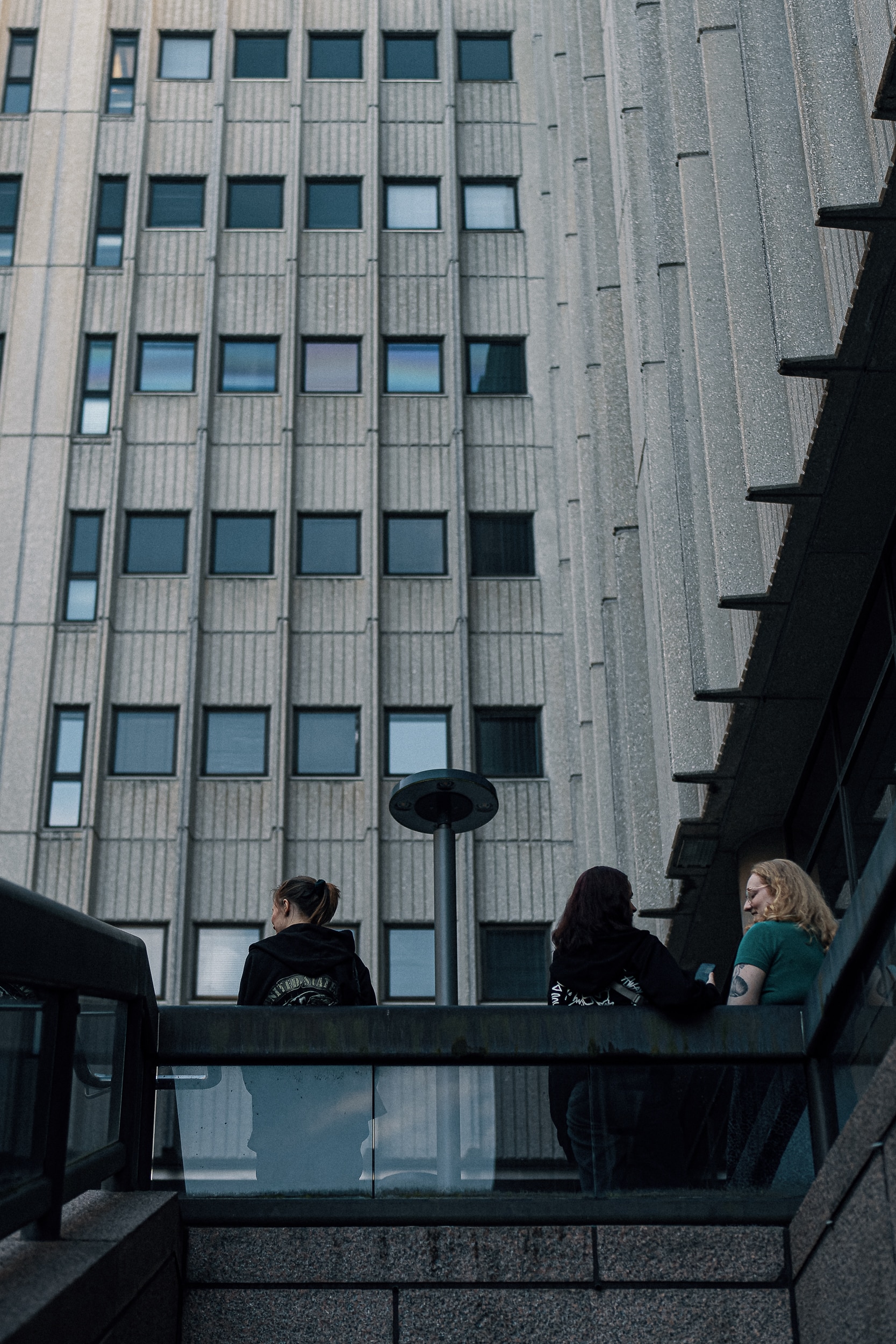 Nuoria seisomassa ja nojaamassa kaiteeseen.